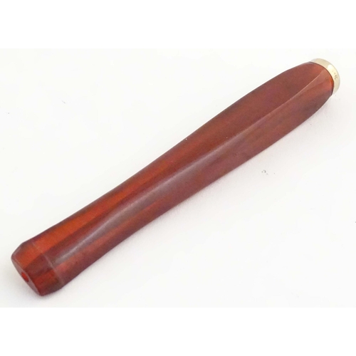 1070 - An Art Deco amber coloured cheroot holder with white metal mount. Approx. 4