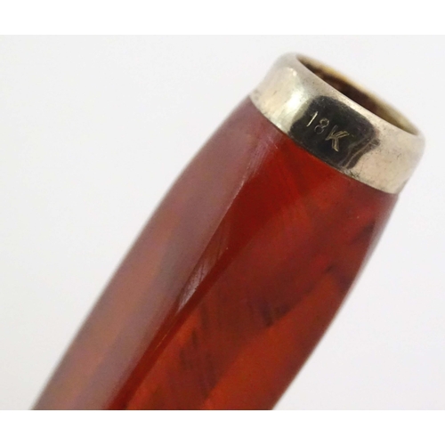 1070 - An Art Deco amber coloured cheroot holder with white metal mount. Approx. 4