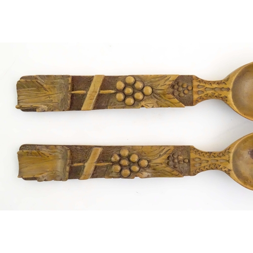 1094 - A pair of Continental carved wooden serving spoons / salad servers with stylised fruiting vine decor... 