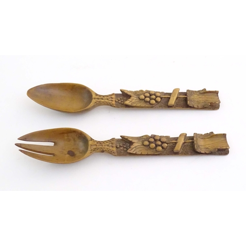 1094 - A pair of Continental carved wooden serving spoons / salad servers with stylised fruiting vine decor... 