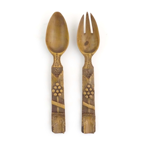 1094 - A pair of Continental carved wooden serving spoons / salad servers with stylised fruiting vine decor... 