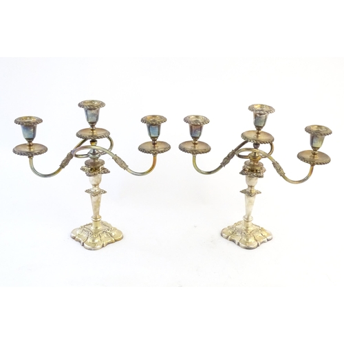 552 - A pair of silver plate candlesticks by Barker Ellis with associated silver plate three branch sconce... 