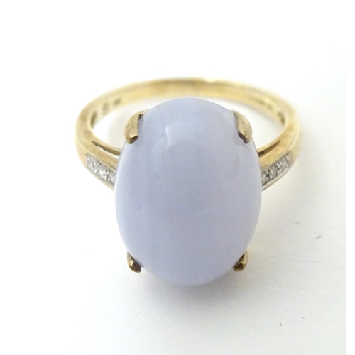 577 - A 9ct gold dress ring set with lace agate cabochon flanked by three diamonds to each shoulder. Ring ... 