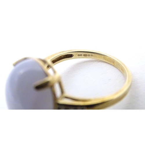 577 - A 9ct gold dress ring set with lace agate cabochon flanked by three diamonds to each shoulder. Ring ... 