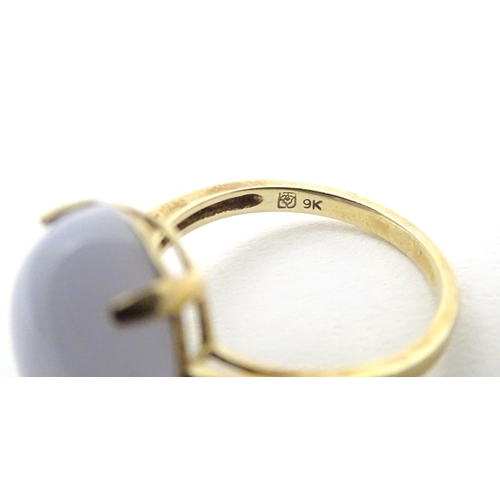 577 - A 9ct gold dress ring set with lace agate cabochon flanked by three diamonds to each shoulder. Ring ... 