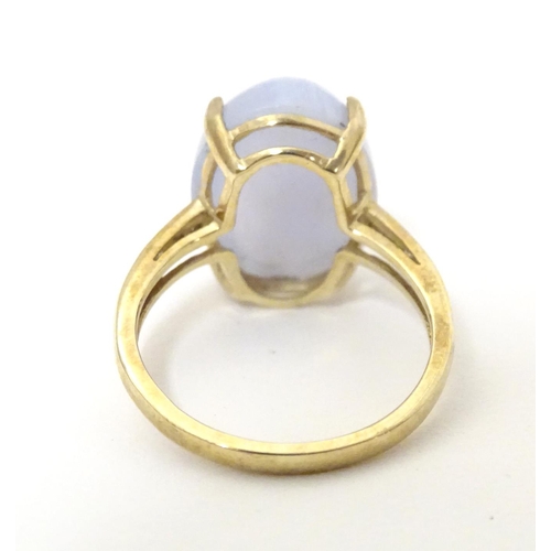 577 - A 9ct gold dress ring set with lace agate cabochon flanked by three diamonds to each shoulder. Ring ... 