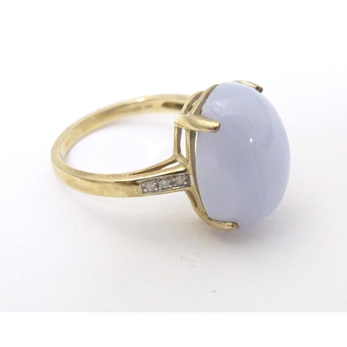 577 - A 9ct gold dress ring set with lace agate cabochon flanked by three diamonds to each shoulder. Ring ... 