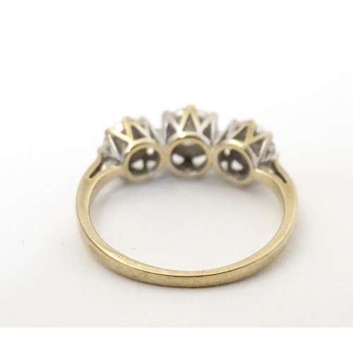 583 - A 9ct gold ring set with a trio of diamonds. Ring size approx. K 1/2