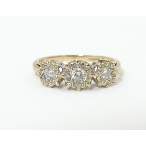 583 - A 9ct gold ring set with a trio of diamonds. Ring size approx. K 1/2