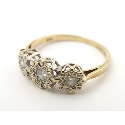 583 - A 9ct gold ring set with a trio of diamonds. Ring size approx. K 1/2