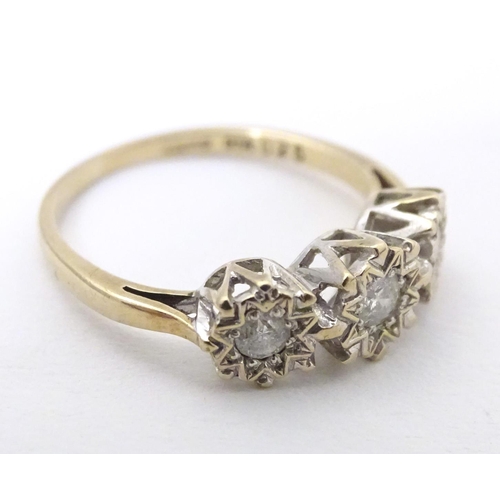 583 - A 9ct gold ring set with a trio of diamonds. Ring size approx. K 1/2