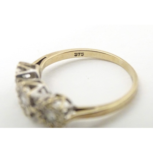 583 - A 9ct gold ring set with a trio of diamonds. Ring size approx. K 1/2