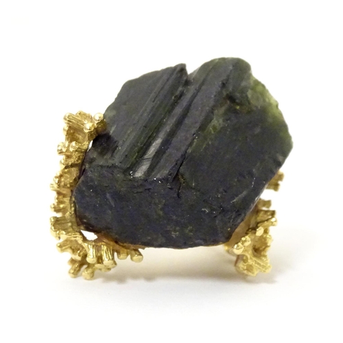 587 - An unusual 18ct gold ring set with black jet coloured hardstone specimen with textured shoulders. Ri... 