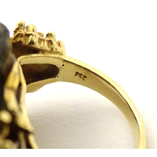 587 - An unusual 18ct gold ring set with black jet coloured hardstone specimen with textured shoulders. Ri... 