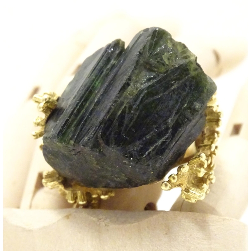 587 - An unusual 18ct gold ring set with black jet coloured hardstone specimen with textured shoulders. Ri... 