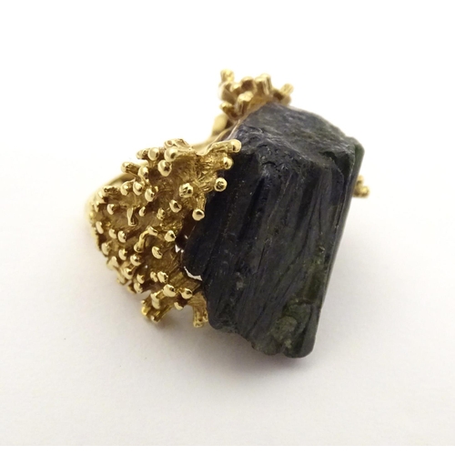 587 - An unusual 18ct gold ring set with black jet coloured hardstone specimen with textured shoulders. Ri... 