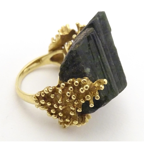 587 - An unusual 18ct gold ring set with black jet coloured hardstone specimen with textured shoulders. Ri... 