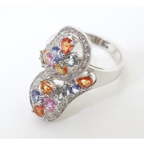 589 - A 18ct white gold dress ring set with various coloured stones. Ring size approx. N 1/2