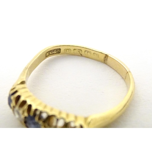 590 - An 18ct gold ring set with diamonds, sapphire and blue stone detail. Ring size approx. N