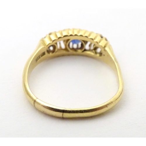 590 - An 18ct gold ring set with diamonds, sapphire and blue stone detail. Ring size approx. N