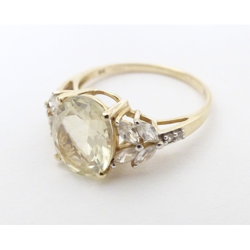 591 - A 9ct gold dress ring set with central oval serenite flanked by four white topaz to each shoulder. R... 