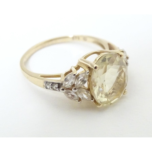 591 - A 9ct gold dress ring set with central oval serenite flanked by four white topaz to each shoulder. R... 