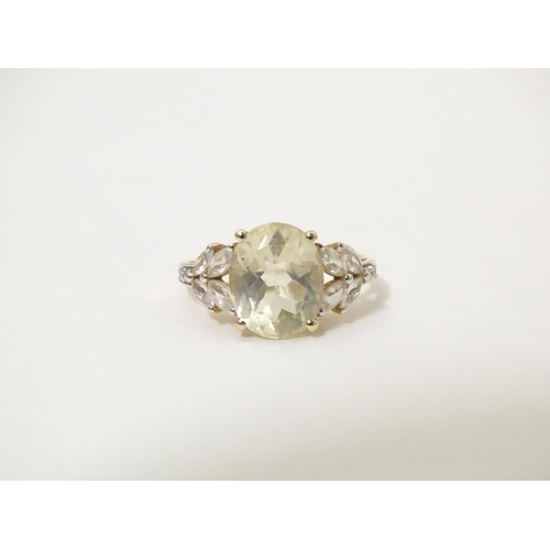 591 - A 9ct gold dress ring set with central oval serenite flanked by four white topaz to each shoulder. R... 