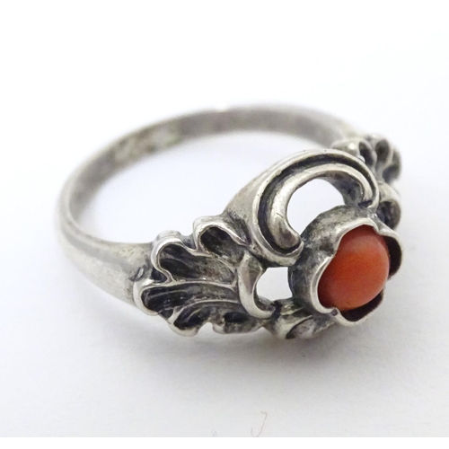 594 - A Continental .800 white metal ring set with coral cabochon. Ring size approx. P