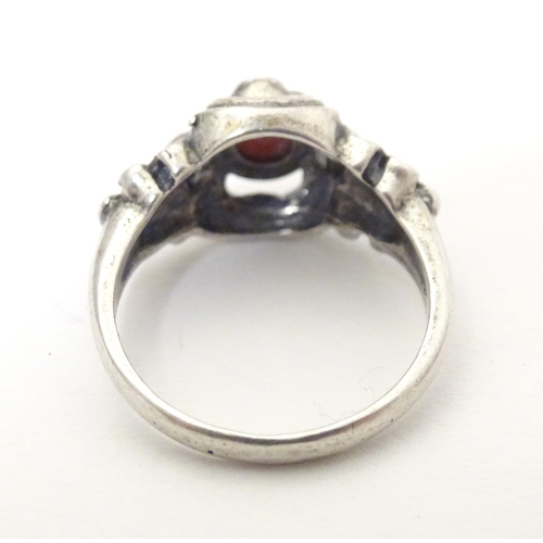 594 - A Continental .800 white metal ring set with coral cabochon. Ring size approx. P