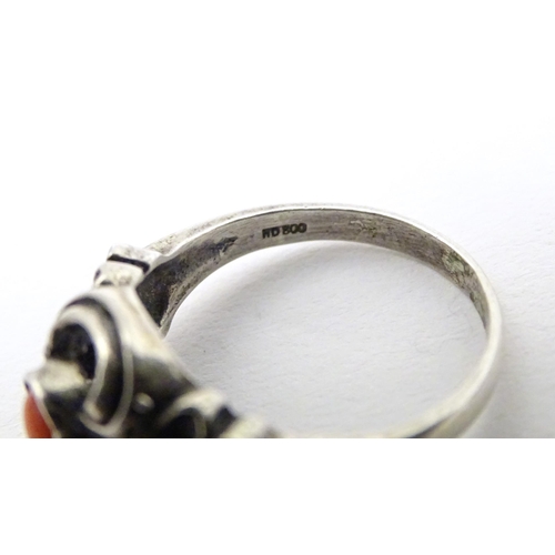 594 - A Continental .800 white metal ring set with coral cabochon. Ring size approx. P