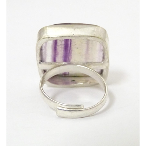 595 - A silver dress ring set with blue john style cabochon to top.