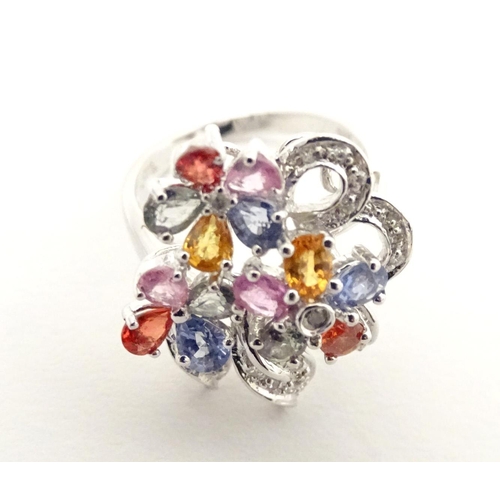 597 - A 18ct white gold dress ring set with various coloured stones. Ring size approx. N