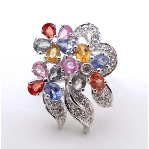 597 - A 18ct white gold dress ring set with various coloured stones. Ring size approx. N