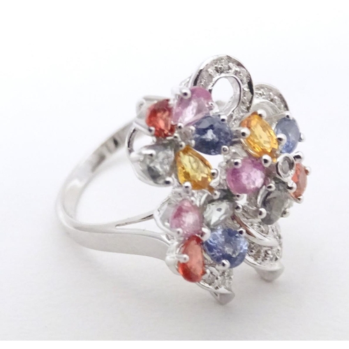 597 - A 18ct white gold dress ring set with various coloured stones. Ring size approx. N