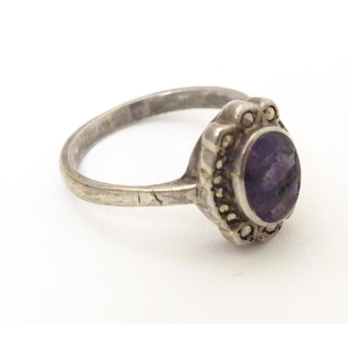 600 - A silver ring set with blue john style cabochon bordered by marcasite. Ring size approx. M 1/2