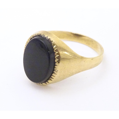 601 - A gentleman's 9ct gold signet ring set with onyx. Ring size approx. X 1/2