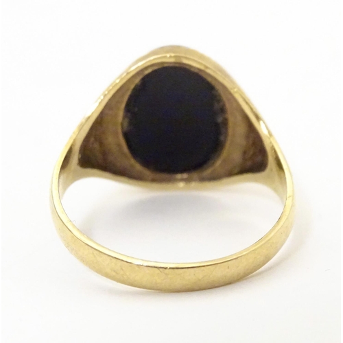 601 - A gentleman's 9ct gold signet ring set with onyx. Ring size approx. X 1/2