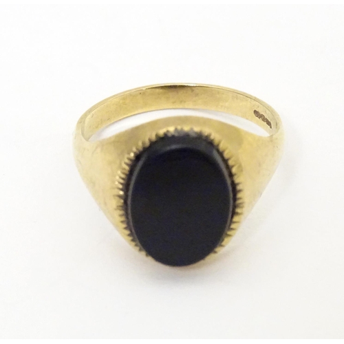 601 - A gentleman's 9ct gold signet ring set with onyx. Ring size approx. X 1/2