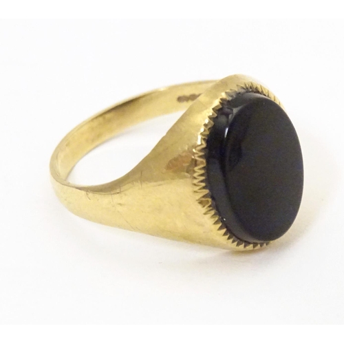 601 - A gentleman's 9ct gold signet ring set with onyx. Ring size approx. X 1/2