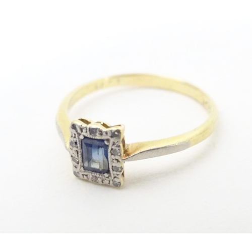 609 - An 18ct gold ring set with central sapphire bordered by diamonds in a platinum setting. Ring size ap... 