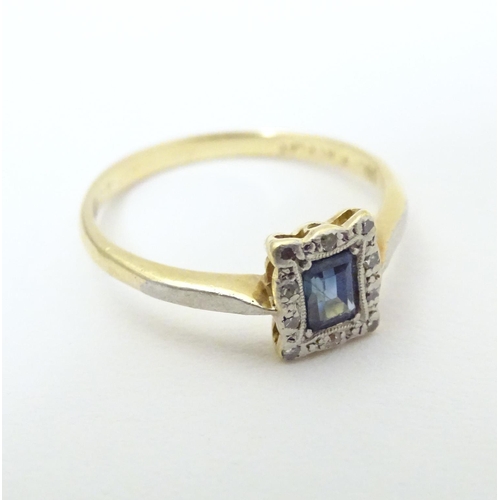 609 - An 18ct gold ring set with central sapphire bordered by diamonds in a platinum setting. Ring size ap... 