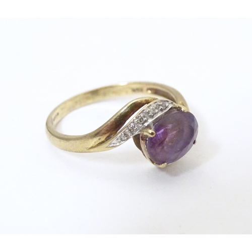 610 - A 9ct gold ring set with central amethyst flanked by diamonds. Ring size approx. R