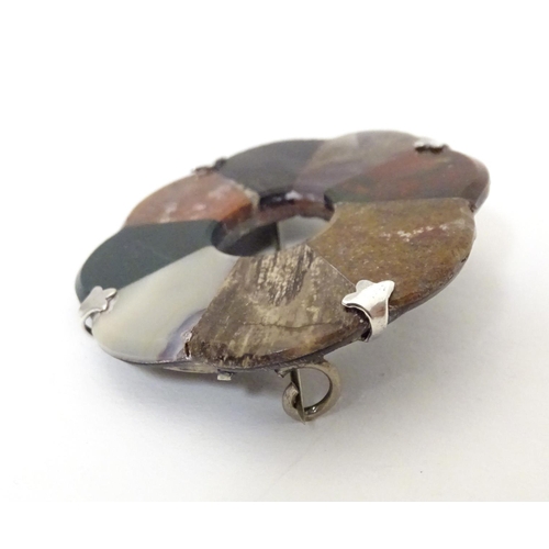 612 - A Scottish agate hardstone brooch of roundel form with white metal mounts. Approx 2