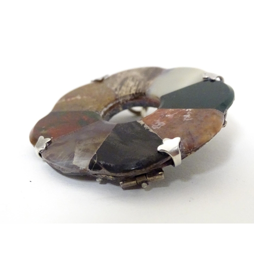 612 - A Scottish agate hardstone brooch of roundel form with white metal mounts. Approx 2