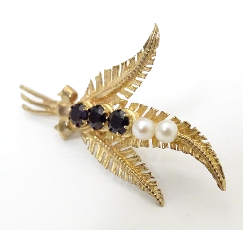 615 - A 9ct gold brooch of foliate sprig form set with garnets and pearls. Aprox 1 3/4