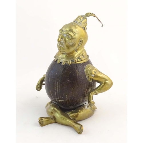 1187 - An early 20thC novelty brass and coconut inkwell modelled as a seated man wearing a plume hat. Appro... 