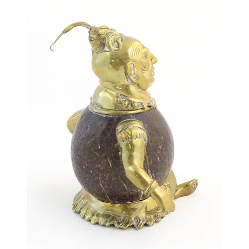 1187 - An early 20thC novelty brass and coconut inkwell modelled as a seated man wearing a plume hat. Appro... 