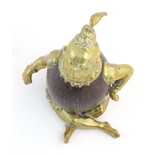 1187 - An early 20thC novelty brass and coconut inkwell modelled as a seated man wearing a plume hat. Appro... 