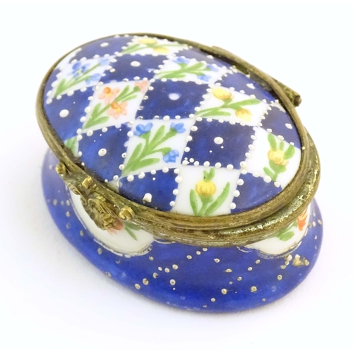 1206 - A 19thC Bilston / Battersea enamel pill box of oval form with a waisted body, the lid decorated with... 