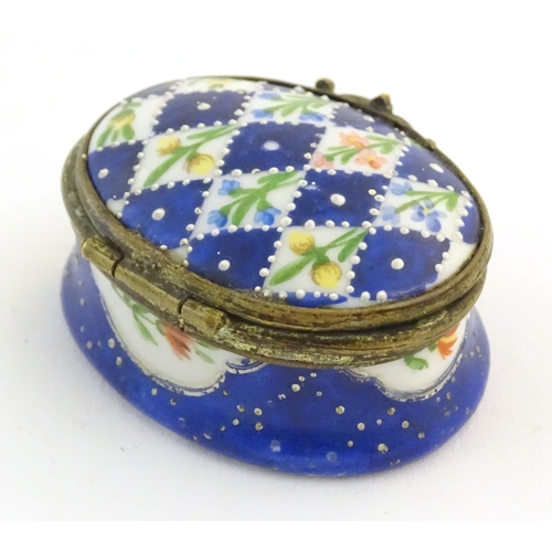 1206 - A 19thC Bilston / Battersea enamel pill box of oval form with a waisted body, the lid decorated with... 